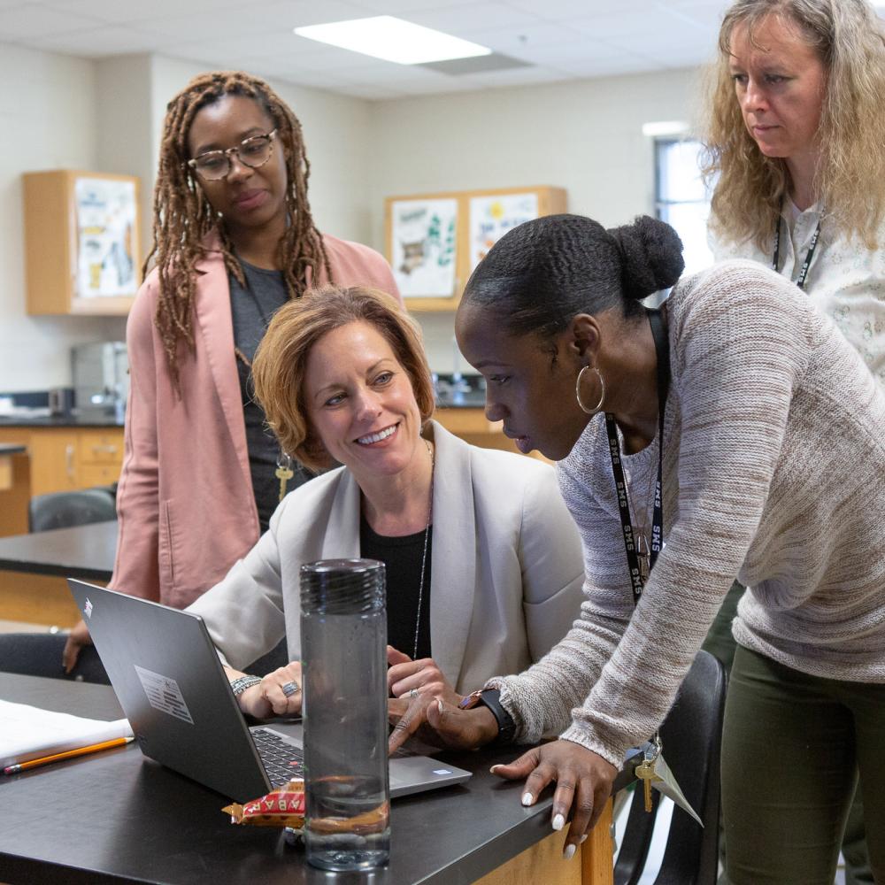 4 women teachers discuss with computer