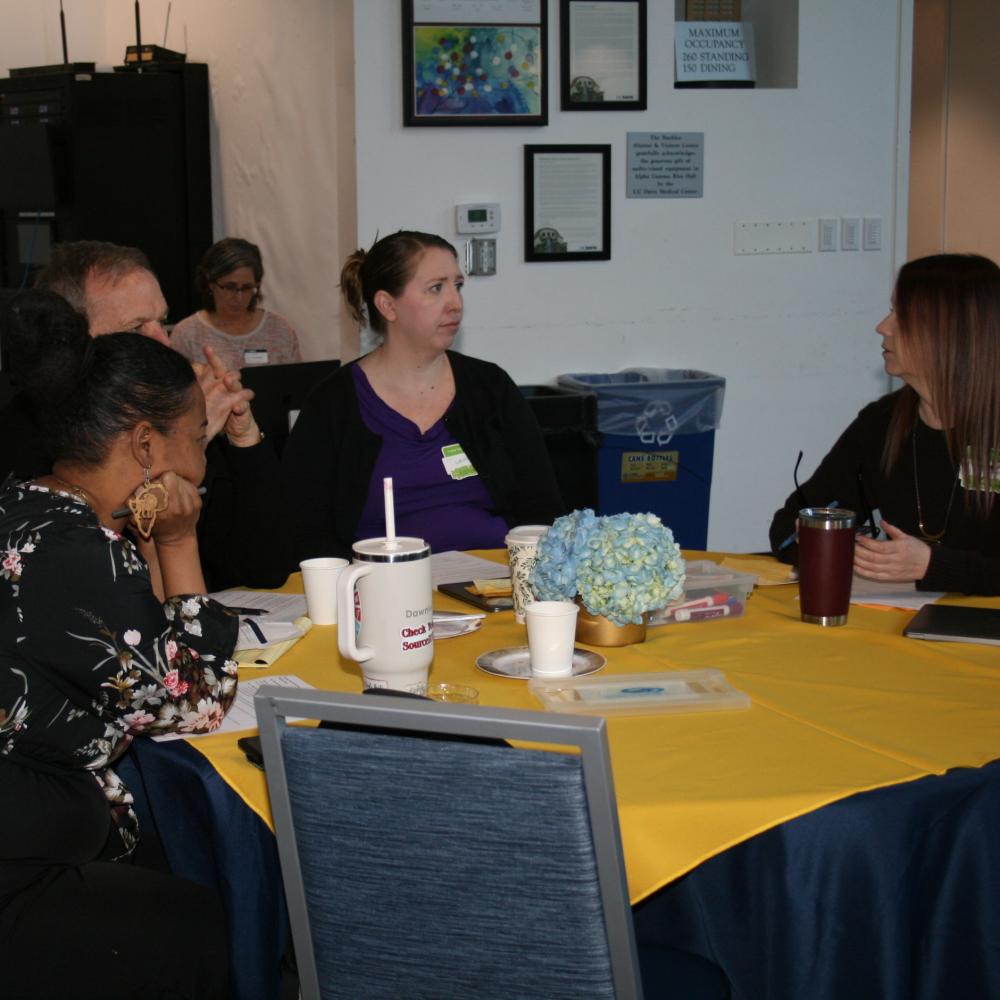 5 people talking at table